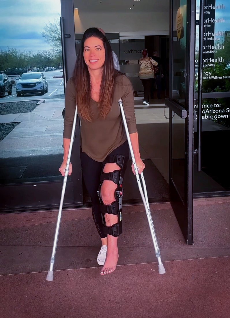 Felecia on crutches with a knee brace, learning to walk again
